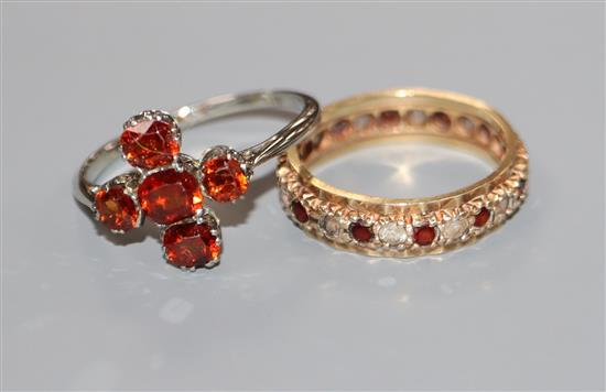 An 18ct white gold and five-stone hessonite garnet set cluster ring and a 9ct gold, ruby and diamond eternity ring.
